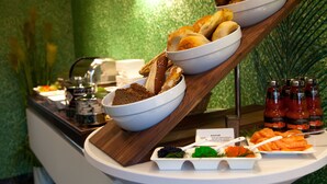 Un buffet proposant une variété de plats, notamment du pain, du saumon et des condiments.