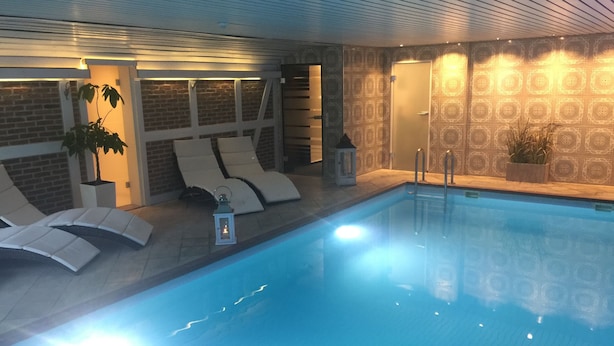 A swimming pool with lounge chairs and a lantern. - Hotel Petersen‘s Landhaus Scharbeutz (Scharbeutz)