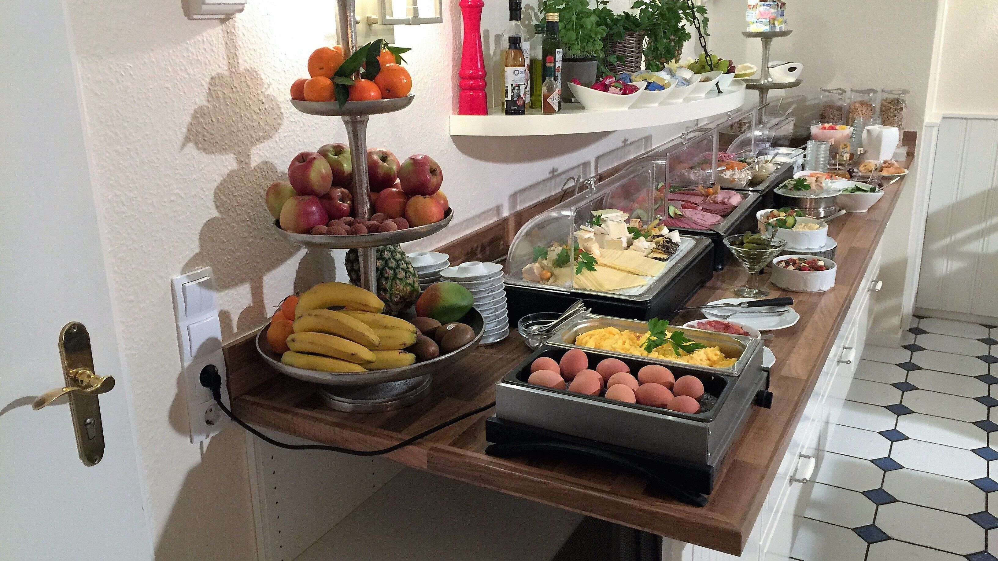 A buffet with various fruits, cheeses, and meats.
