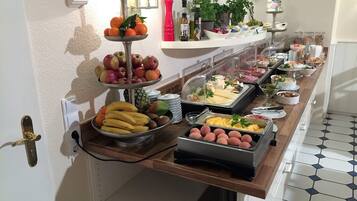 A buffet with various fruits, cheeses, and meats.