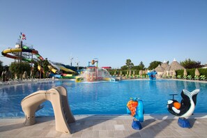 A swimming pool with a water slide, lounge chairs, and a mermaid statue. - Trulli San Leonardo (Alberobello)