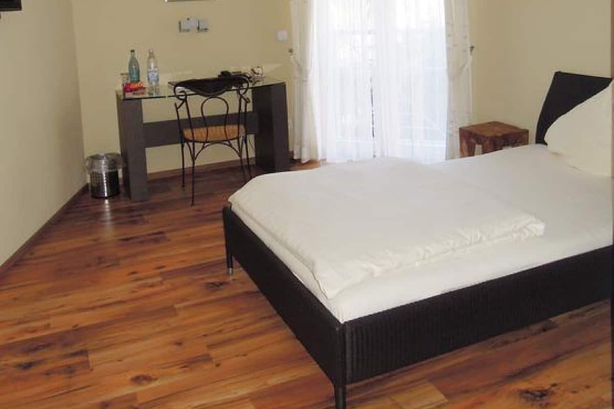 Un dormitorio con una cama, un escritorio, una silla y una mesita.