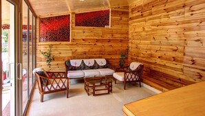 A wooden interior with a sofa set, two chairs, and a coffee table. - Hotel Monarch Residency (Manali)