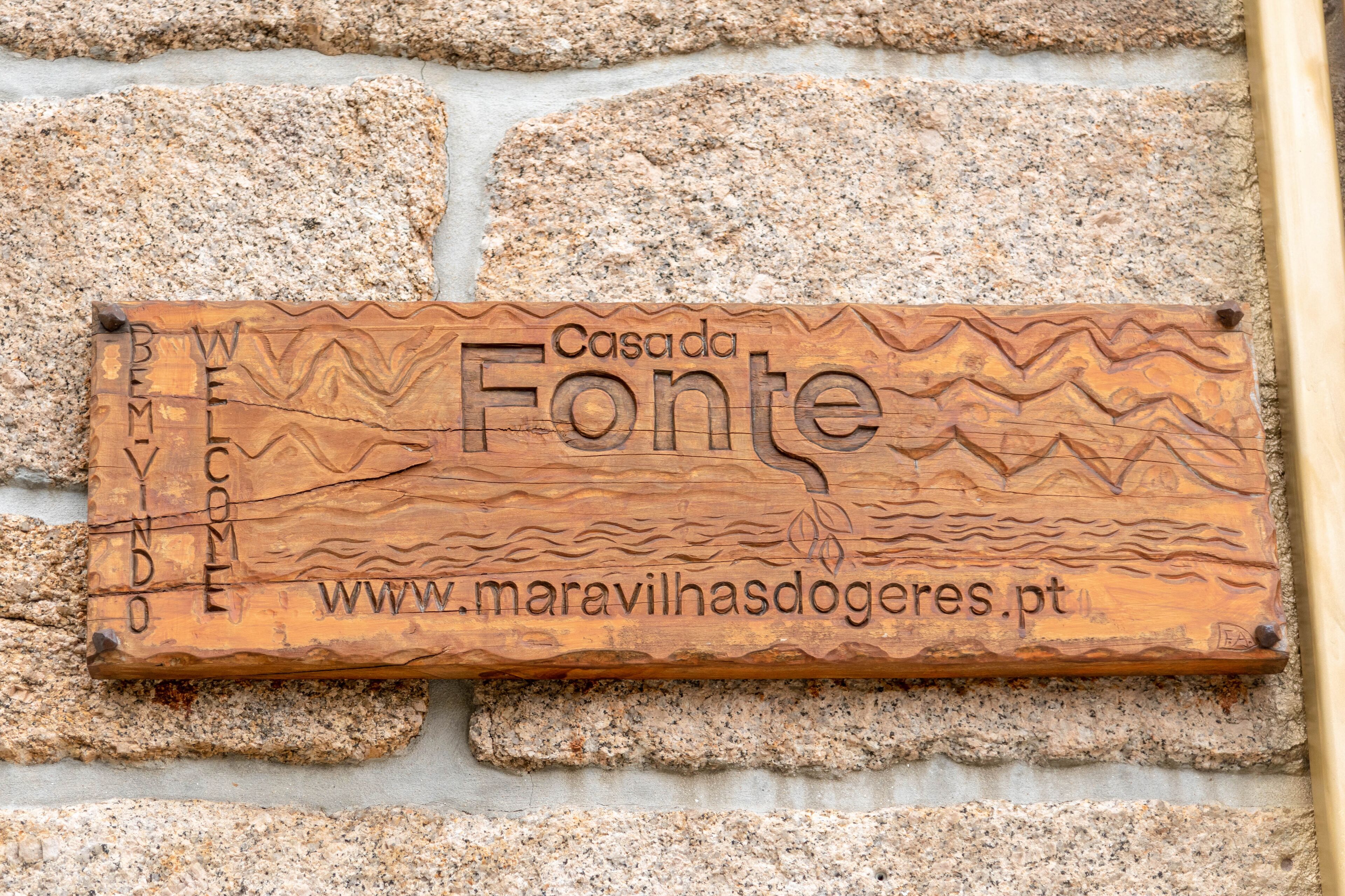 A wooden plaque with the text "Casada Fonte" and a website URL.