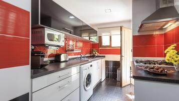 Une cuisine moderne équipée d’un lave-linge, d’un four à micro-ondes et d’une cuisinière.