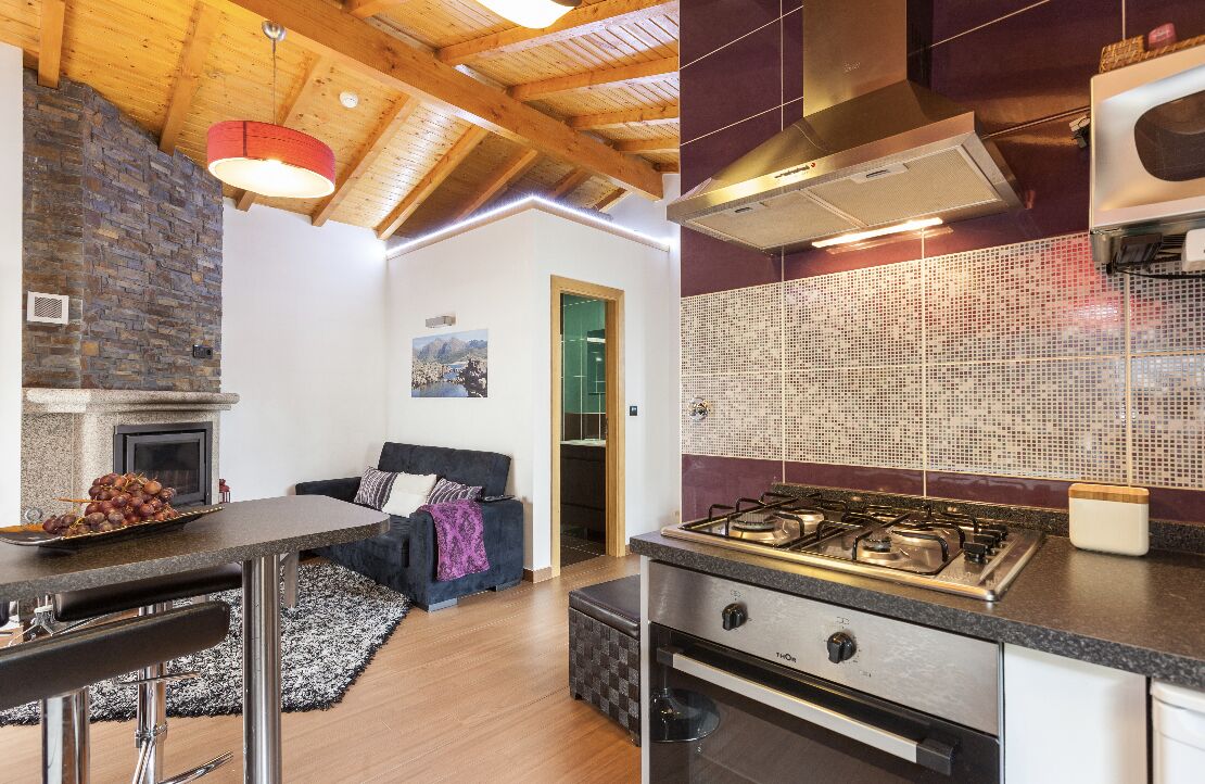Een moderne keuken met een gasfornuis, een inbouwoven en een stenen open haard.
