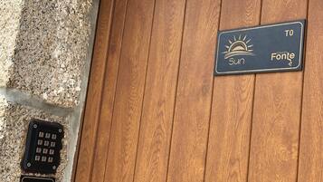 Eine Holztür mit einem Schild, das 'Casa da Fonte' anzeigt, und einem Schlüsselfeld.