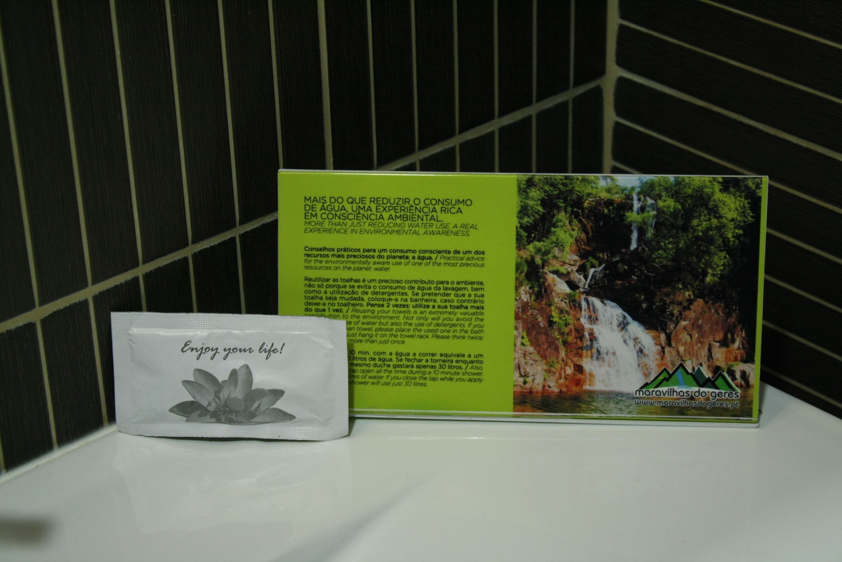 A brochure with a waterfall and a message about water conservation, placed next to a tissue box.
