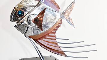 A metal fish sculpture on a stool.