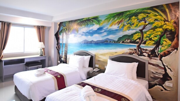 A hotel room with two beds, a desk, and a large beach mural on the wall. - Bcp Hotel Rayong (Ban Chang)