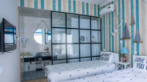 A bedroom with a bed, a bedside table, a mirror, a window with curtains, and a wall-mounted air conditioner. - Snail Home Inn (Huairou)