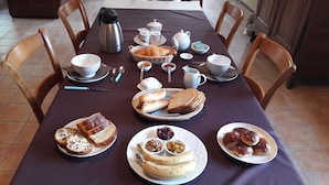 A breakfast setting with bread, pastries, and condiments on a table. - Le Clos des Pensées (Saint-Sauveur-d'Emalleville)