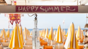 A beach with yellow umbrellas and a 'Happy Summer' sign. - Residence La Palma (Andora)