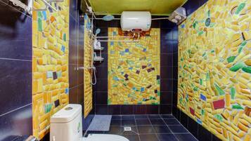 Ett badrum med väggar beklädda med mosaik och en toalett.