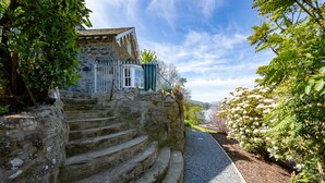 A stone staircase leading to a building with a white door and a blue window. - Taymouth Marina - Port Bane (Aberfeldy)