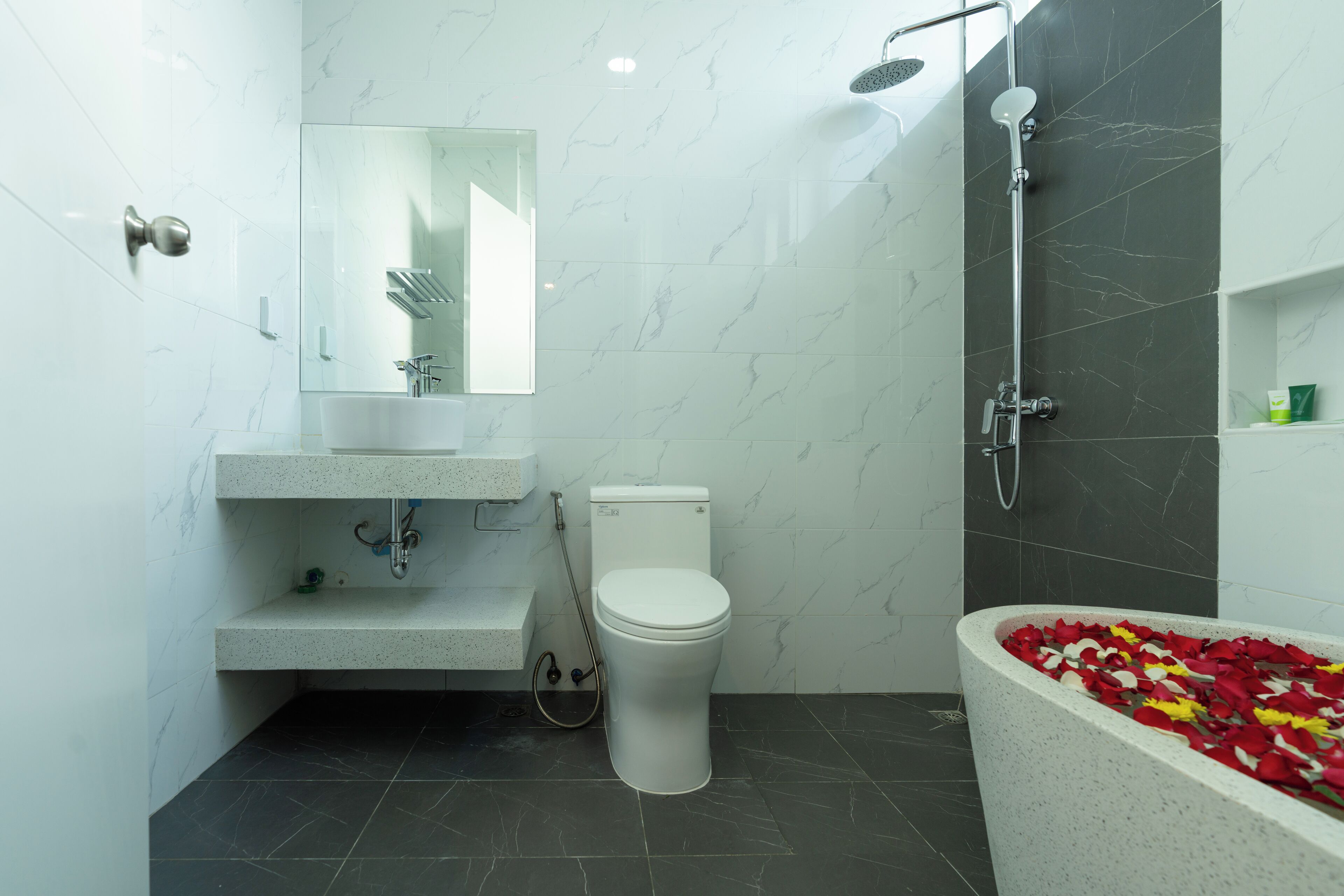 A modern bathroom with a toilet, sink, and shower.