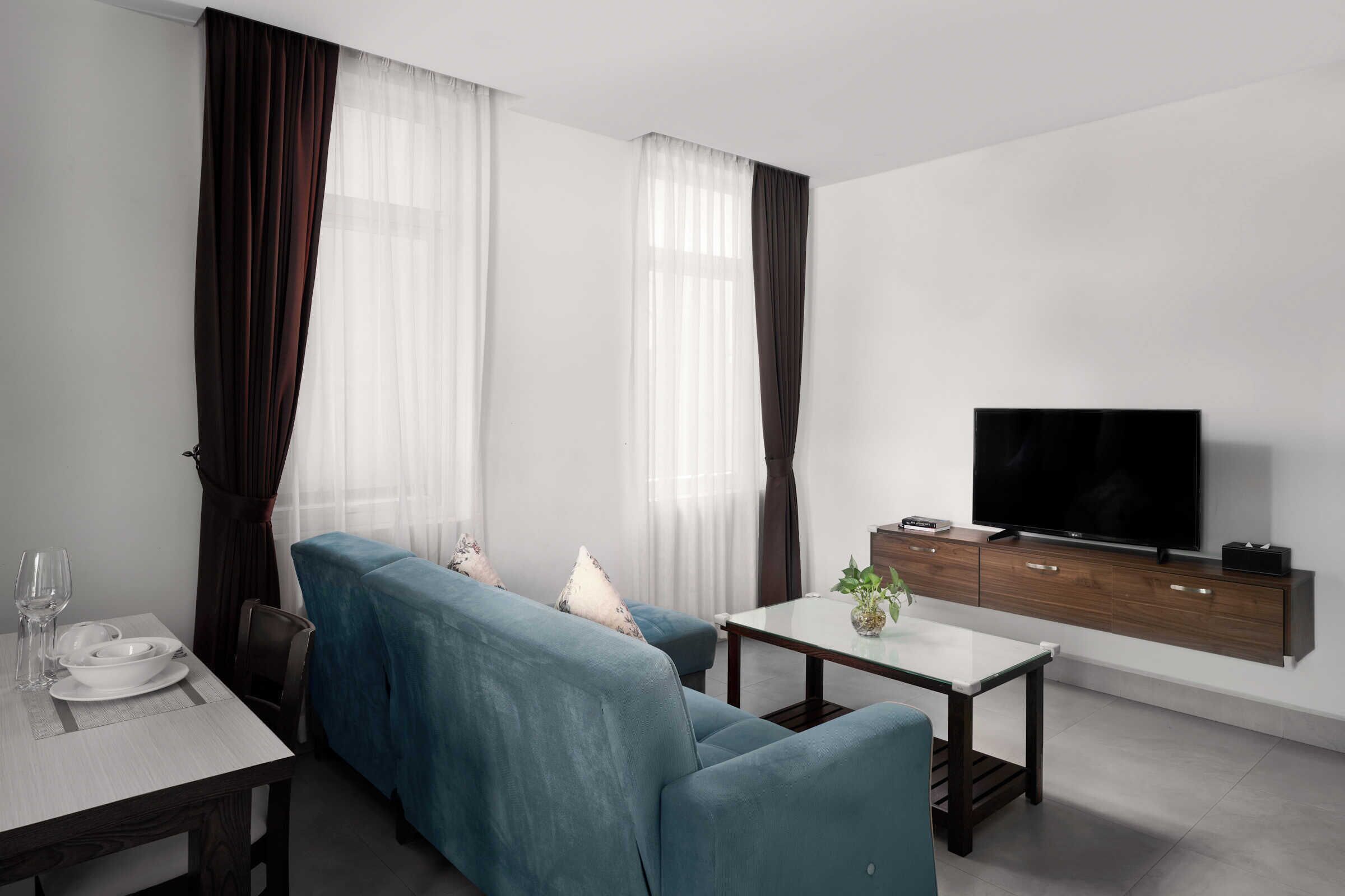 Una sala de estar moderna con un sofá, una mesa de comedor y un televisor.
