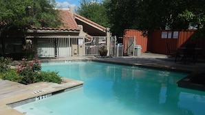 A swimming pool with a 3 FT depth marker, surrounded by a wooden deck and a fenced area.