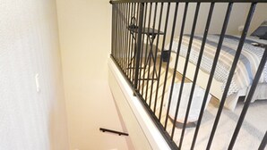 A bedroom with a bed, a nightstand, and a window.