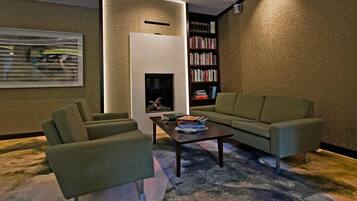A modern living room with a sofa, armchairs, a coffee table, and a bookshelf.