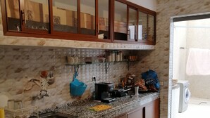Une cuisine avec des armoires en bois, un comptoir en granit et un four encastré.