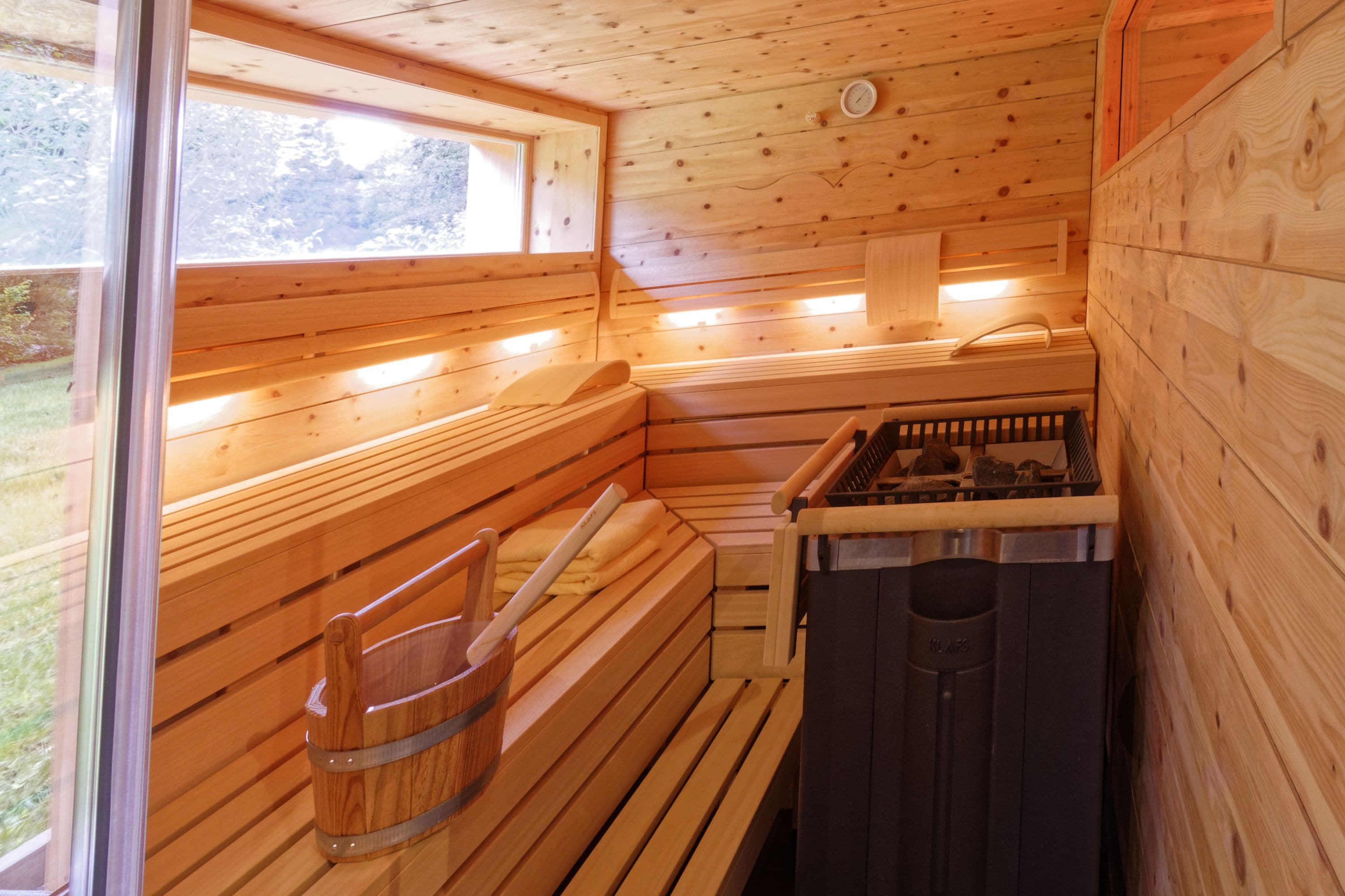 Una sauna con bancos de madera y un generador de vapor.