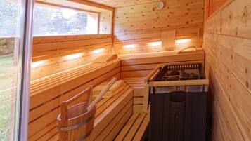 Una sauna con bancos de madera y un generador de vapor.