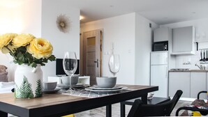 Une cuisine moderne avec des meubles blancs, un four à micro-ondes et un évier.