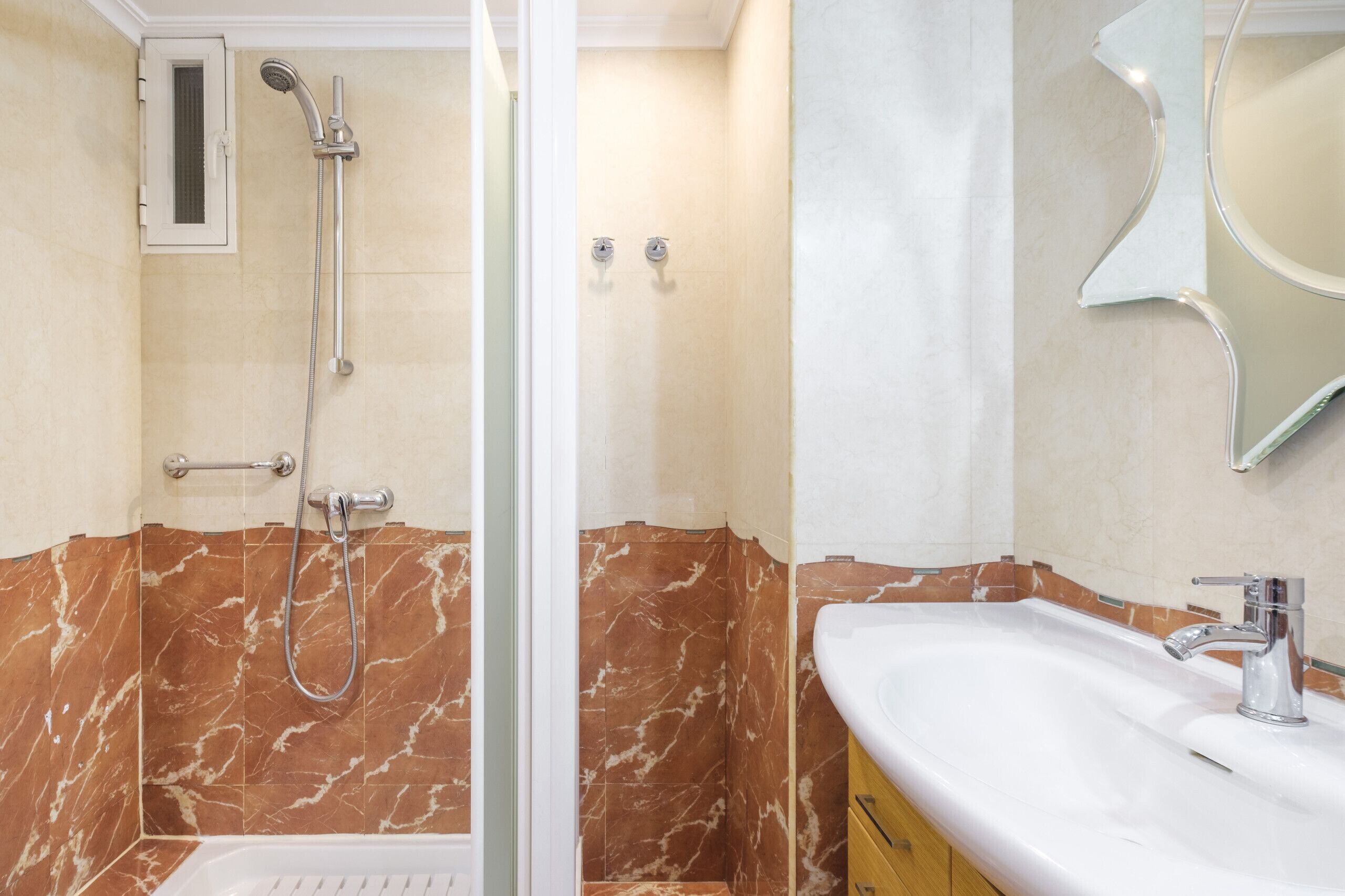 Une salle de bain avec une douche, un lavabo et un miroir.