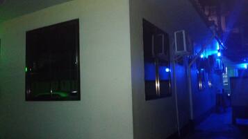 A hallway with a large mirror and two air conditioning units mounted on the wall.