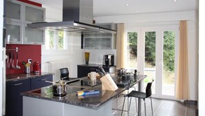 Una cucina moderna con isola centrale, elettrodomestici integrati e vista sul verde.