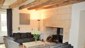 Una sala de estar con chimenea de piedra, un sofá, una mesa de centro y una lámpara.