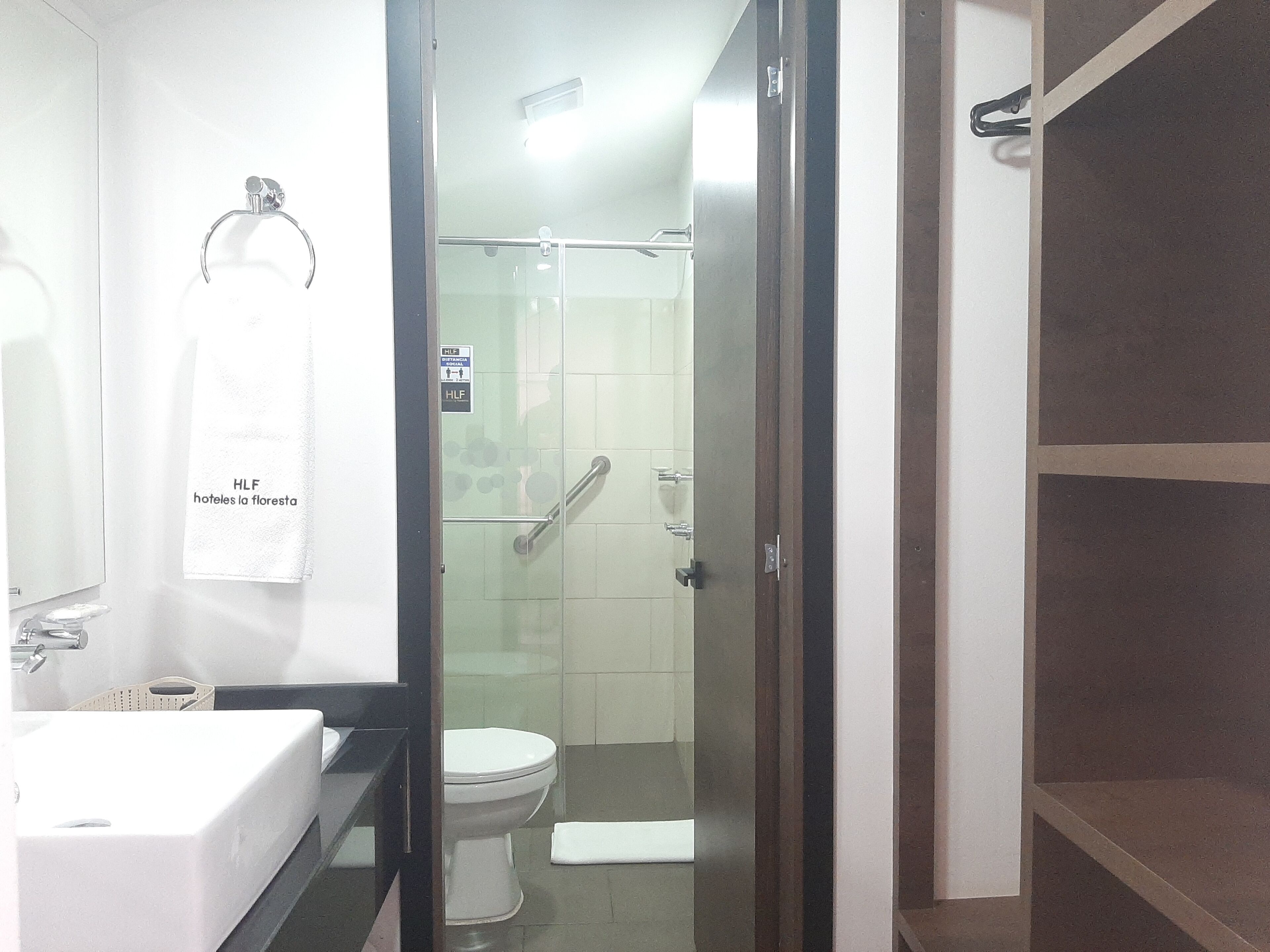 Une salle de bain avec un lavabo blanc, des toilettes et une douche à parois de verre.