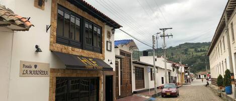 Uma rua de paralelepípedos com um hotel chamado "Posada LA MARINERA" à esquerda.