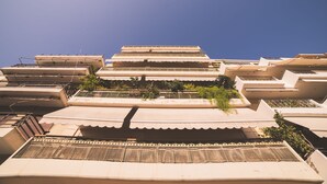 Un immeuble à plusieurs étages, de style architectural uniforme, doté de balcons et d’un toit plat.
