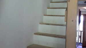 Una escalera con escalones de madera y una pared blanca.