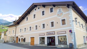 Un immeuble à étages, de style architectural européen traditionnel, qui se distingue par un blason bien visible sur sa façade.