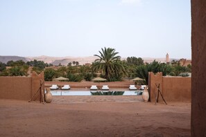 Una piscina al aire libre, sombrillas, sillones reclinables de piscina