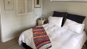 A bedroom with a bed, white walls, and a window with blinds. - Summer vacation in Cape Town, South Africa (Plumstead)
