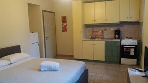 Estúdio, no piso térreo | Cozinha americana privada | Geladeira, fogão, cooktop, cafeteira/chaleira