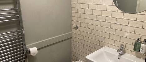 A bathroom with a toilet, a sink, and a towel rack.
