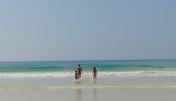 A beach scene with a clear sky and calm sea.