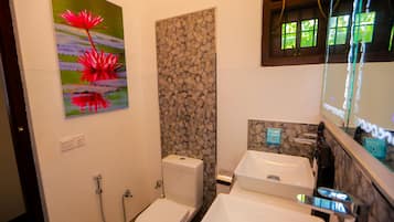 Une salle de bain avec des toilettes, un lavabo et une douche.