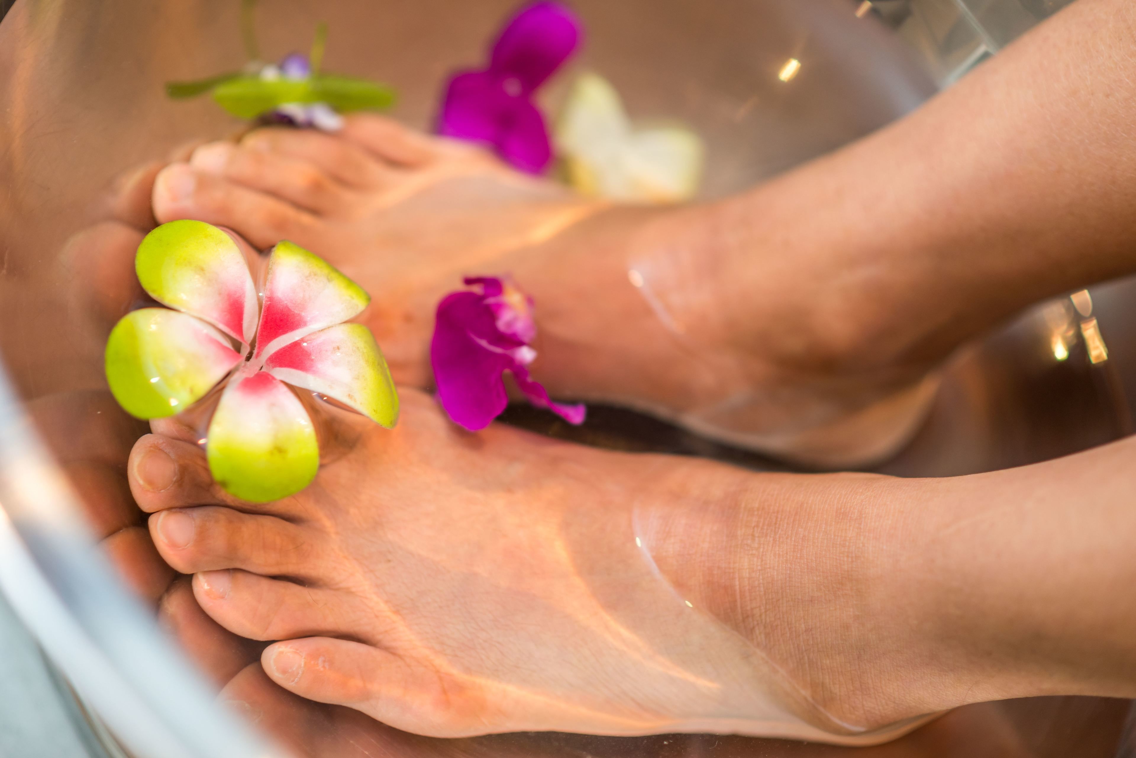 A foot soak with flowers and a foot massager.