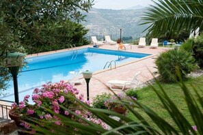 Una piscina al aire libre de temporada, sombrillas
