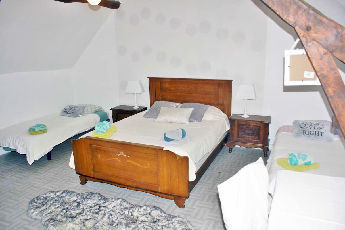 Een slaapkamer met twee bedden, een houten hoofdbord en een behang met patroon.