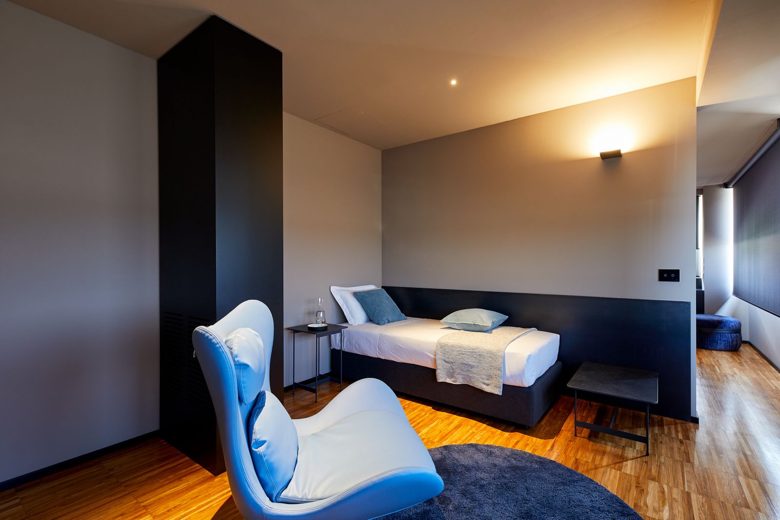 Una camera da letto moderna con un letto, una sedia e un tavolino.