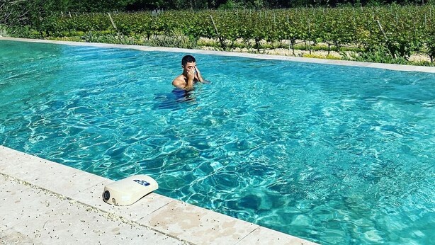 Una piscina azul cristalina rodeada de exuberante follaje y árboles.