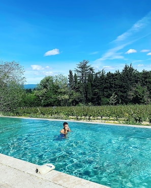 Una piscina azul cristalina rodeada de exuberante follaje y árboles.