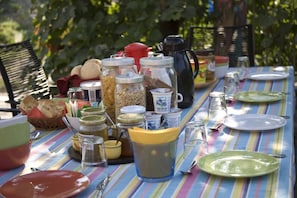 A dining table set outdoors with various food items, utensils, and a coffee pot. - B&B Il Tulipano (Ricco del Golfo di Spezia)